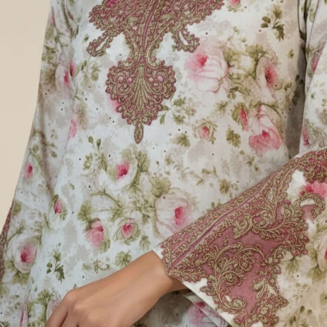 Close-up of a floral and paisley patterned fabric with pink roses and green leaves.